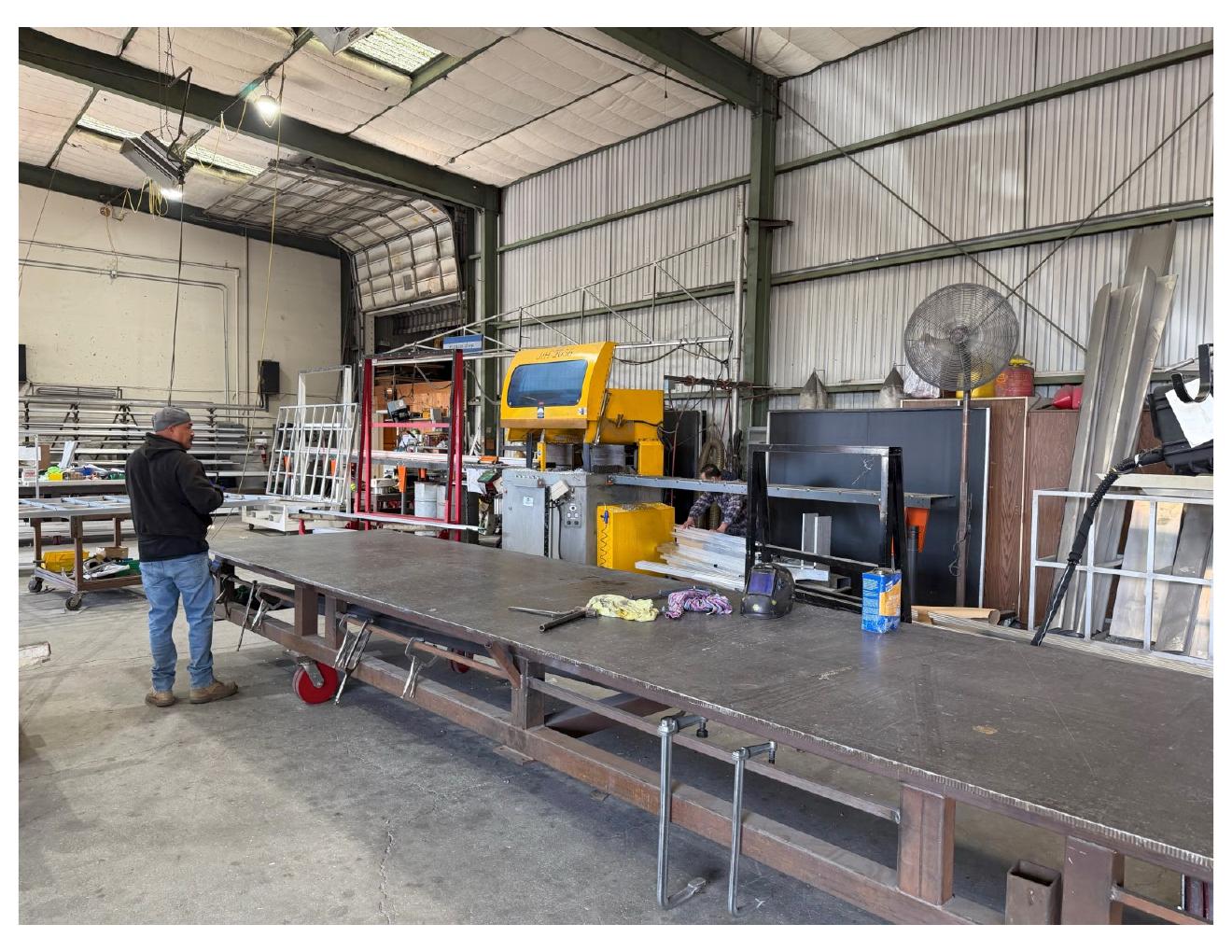Long steel fabrication table on heavy-duty casters